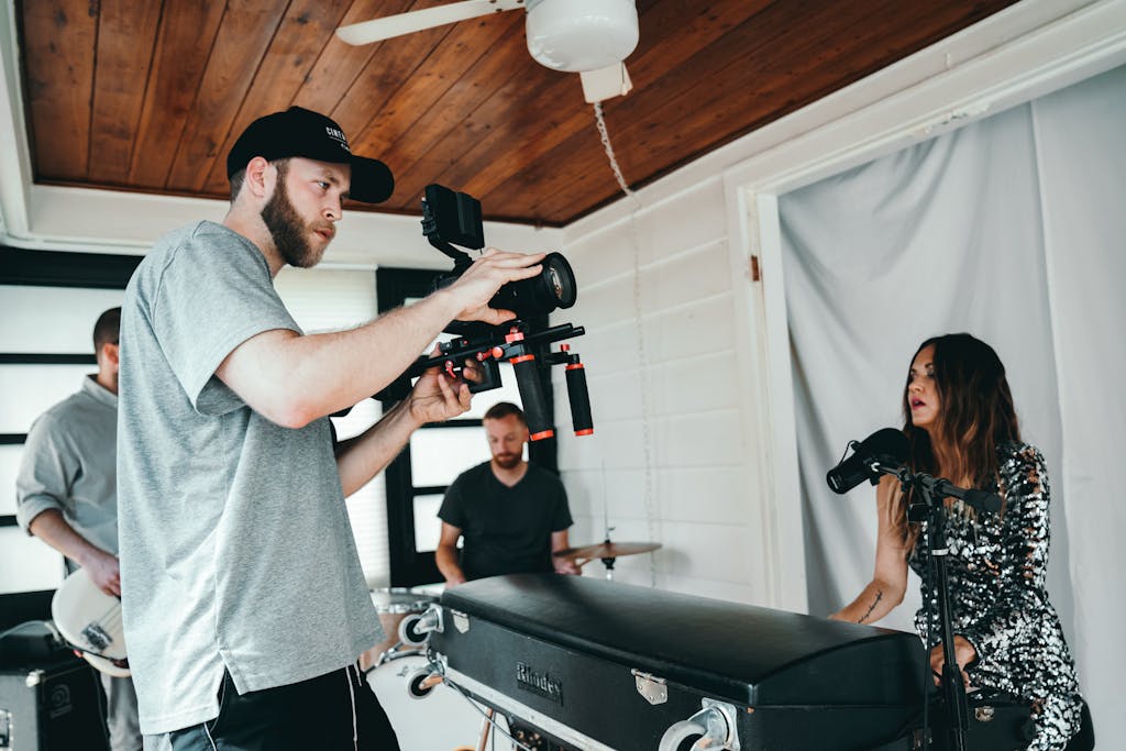 Candid backstage view of a musical video shoot inside a cozy room featuring a band rehearsing.