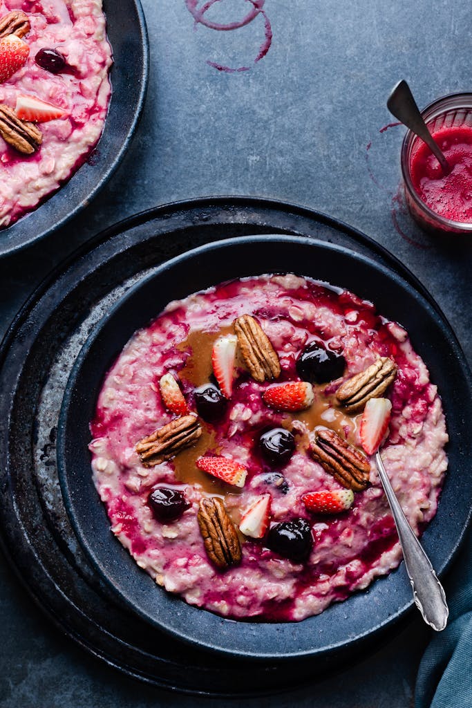 Delicious breakfast oatmeal with strawberries, cherries, and pecans in a vibrant setting.
