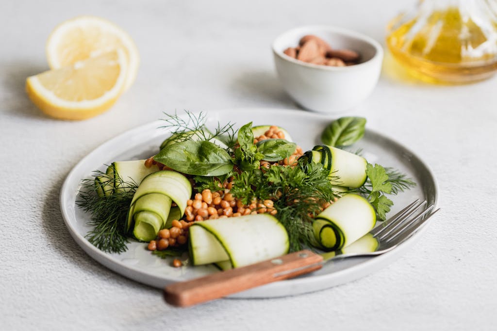 Delicious fresh zucchini salad garnished with dill and lemon slices, beautifully plated.