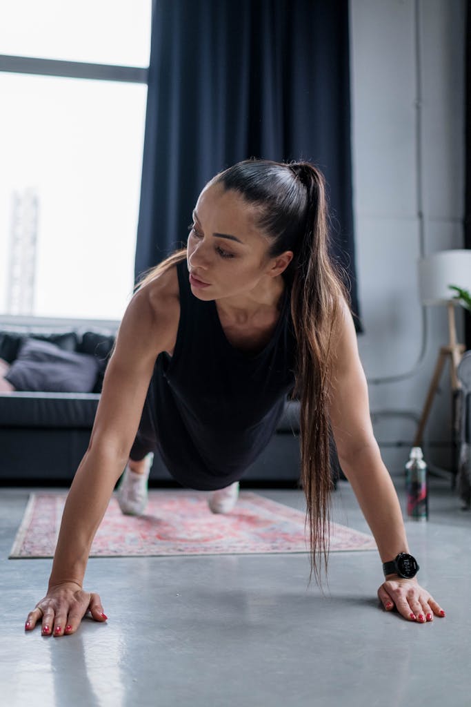 Fit woman performing push-ups indoors showcasing strength and determination.
