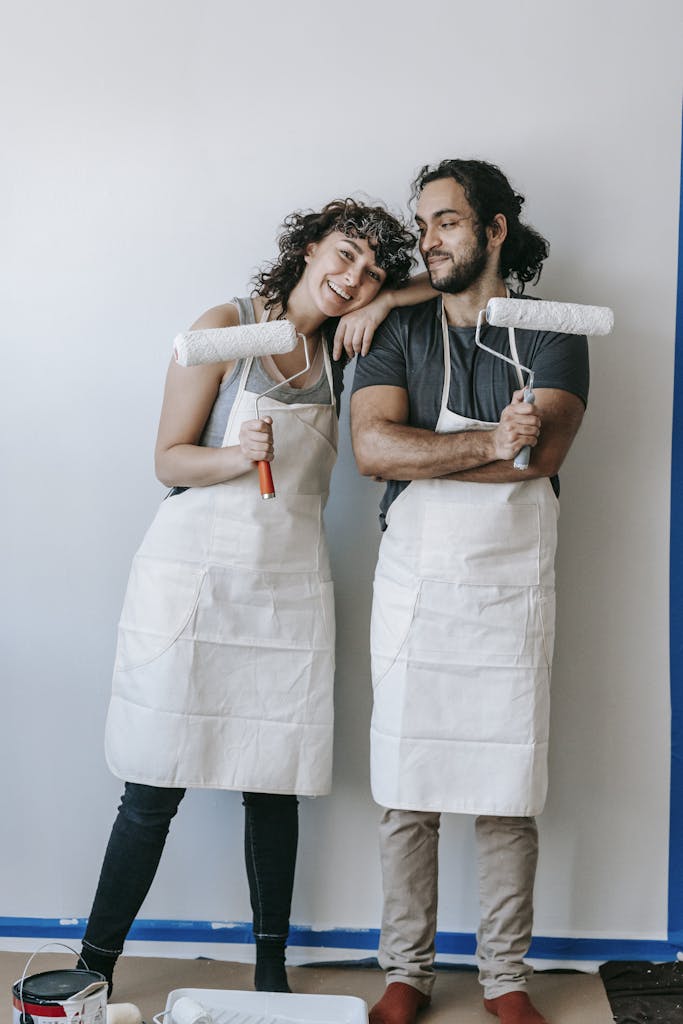 Happy couple painting a wall during a home renovation, creating joyful memories together.