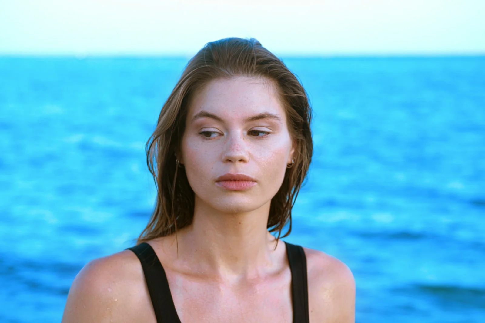 a woman standing in front of a body of water