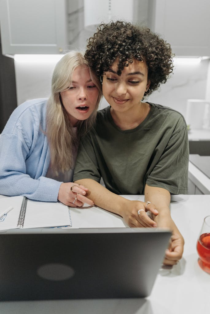 Loving LGBTQ couple spending quality time together at home, watching laptop.