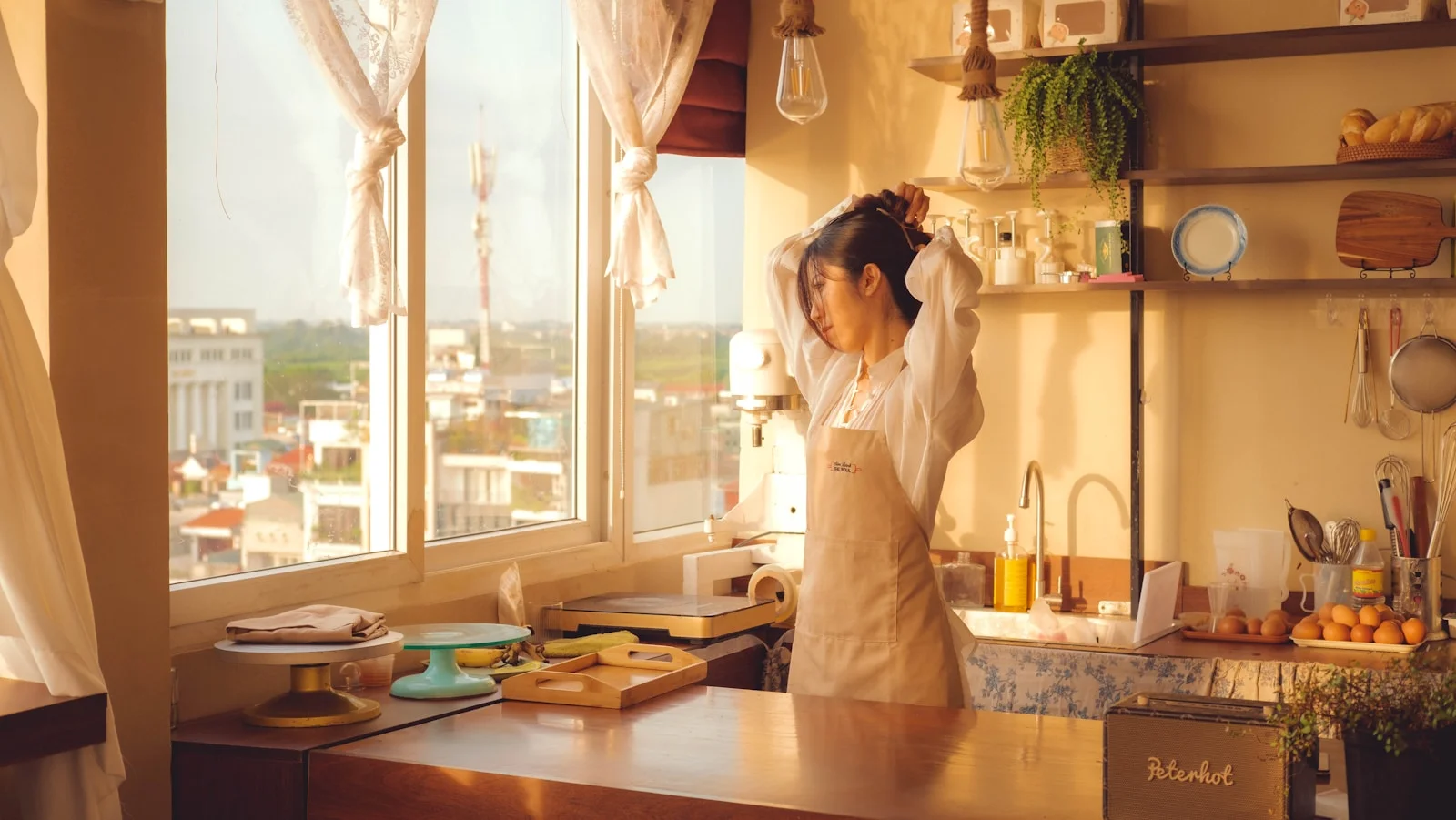 A woman standing in a kitchen next to a window