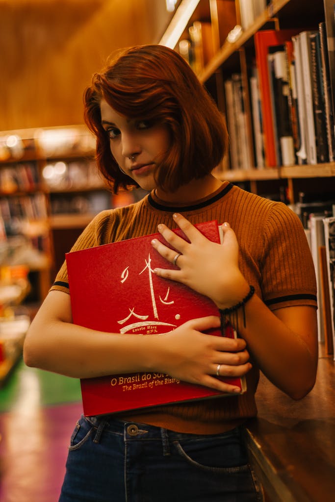 Portrait of a young woman holding a book in a São Paulo library, Brazil.
