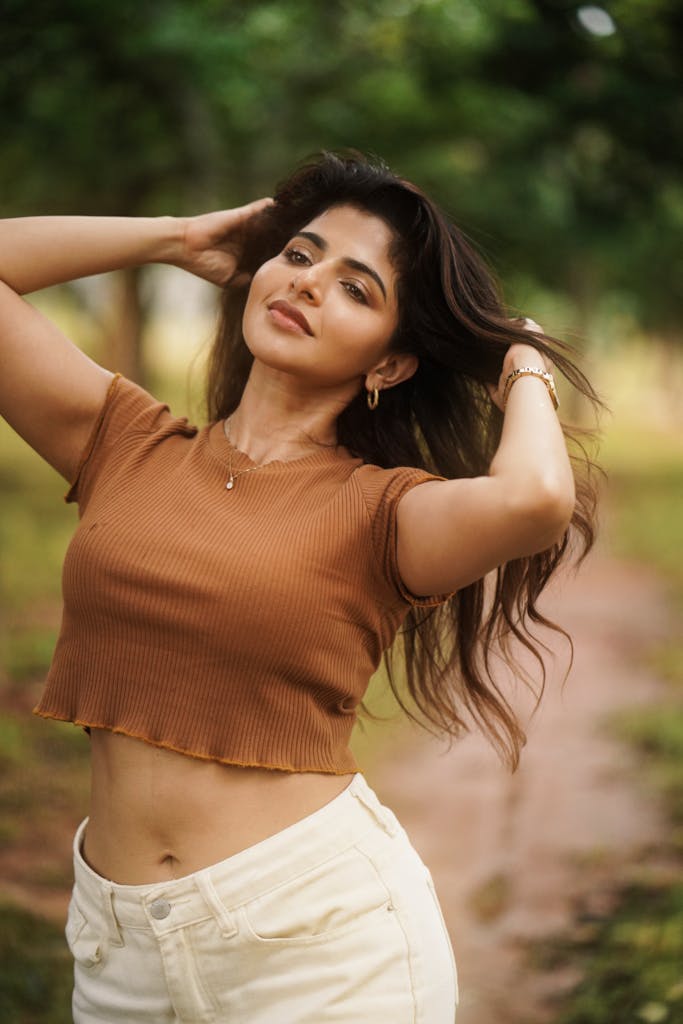 Portrait of a young woman in casual attire, posing confidently on a sunny day outdoors.