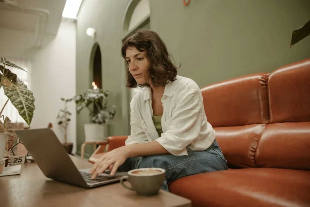 a woman sitting on a couch using a laptop computer