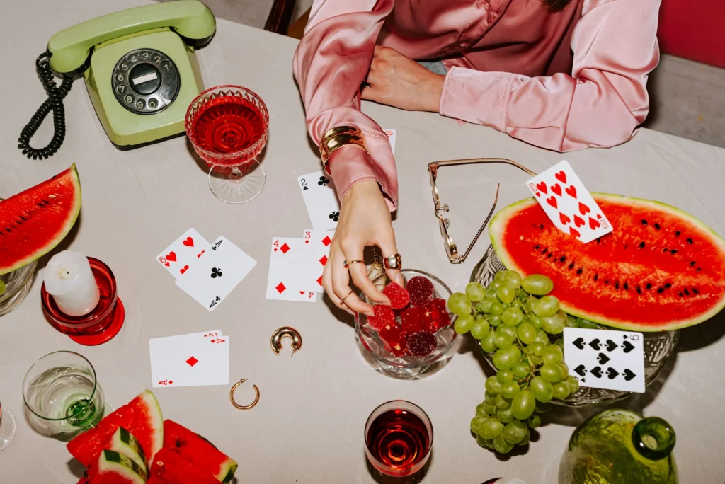 A woman sitting at a table with cards and watermelon