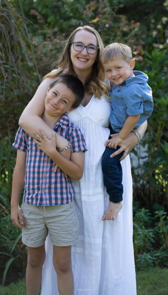 a woman and two boys are posing for a picture