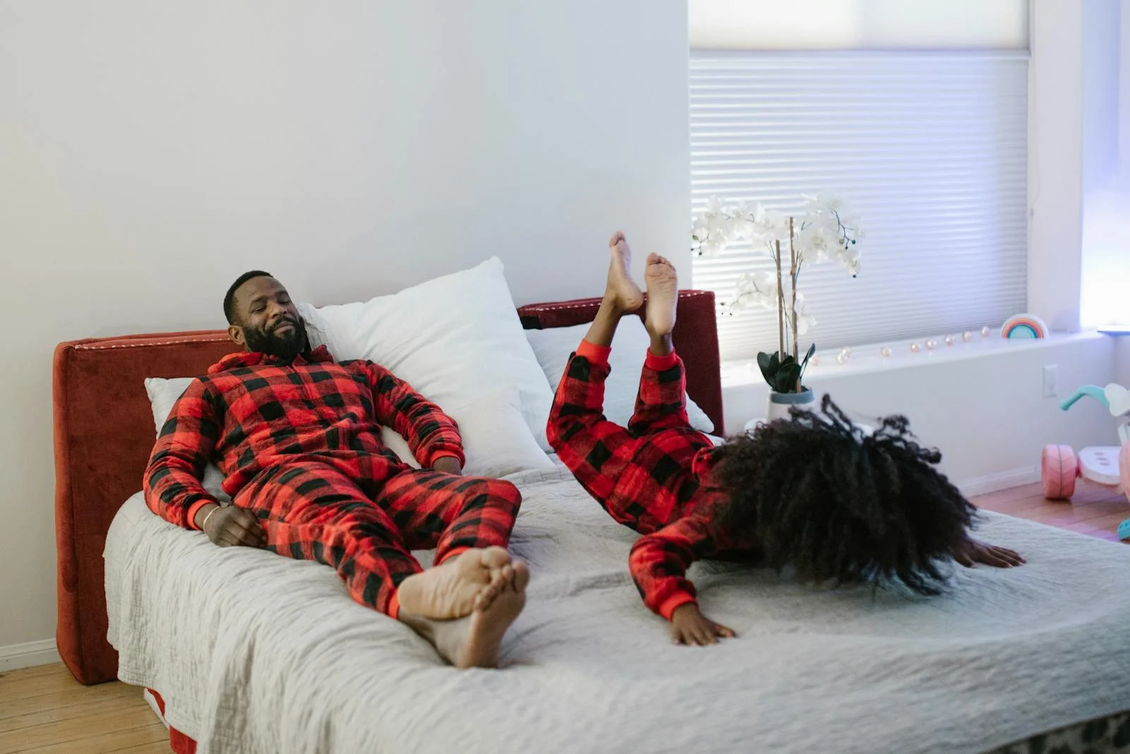 Father and daughter having fun on bed in matching pajamas. A moment of joy and bonding.