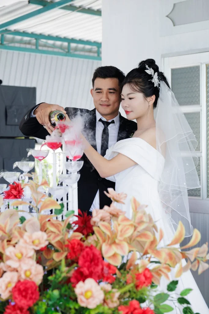 Bride and groom celebrating with champagne at a beautiful indoor wedding ceremony.
