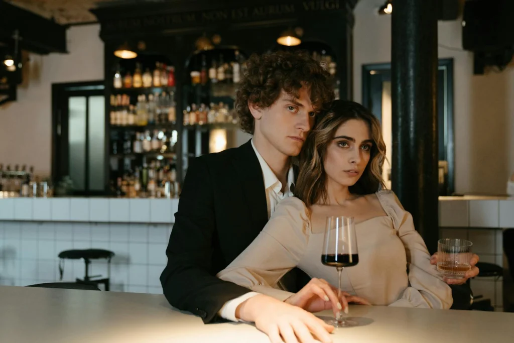 A romantic couple enjoying drinks at an elegant indoor bar setting, embracing a warm ambiance.