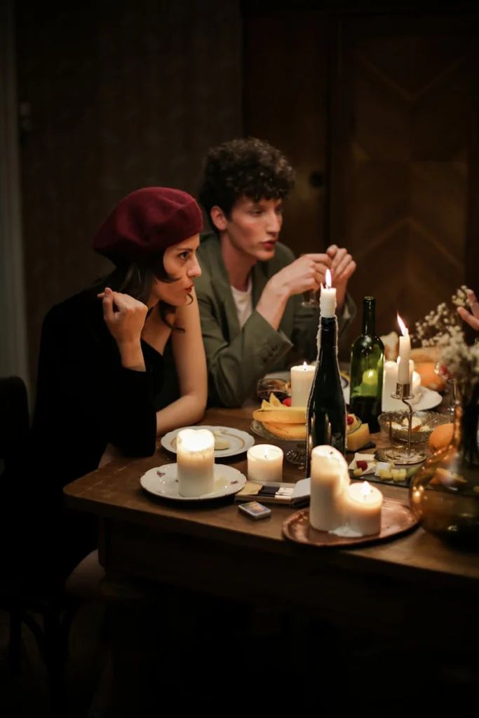 A couple enjoying a romantic candlelit dinner in an intimate setting.