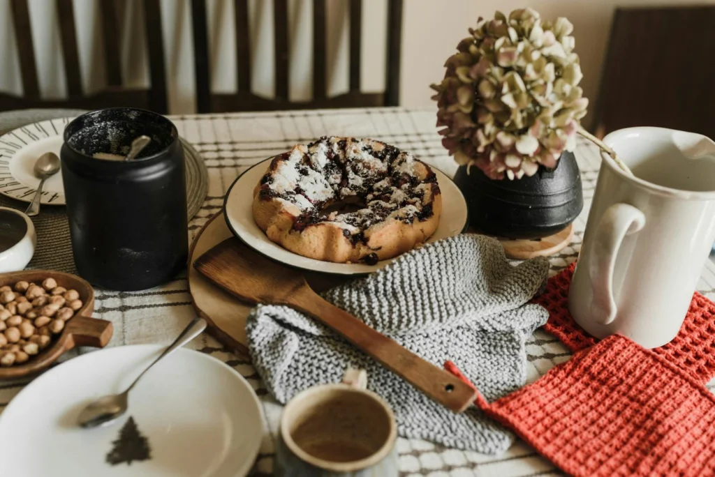 Cozy morning setup with a homemade pastry, coffee, and rustic decor on a wooden table.