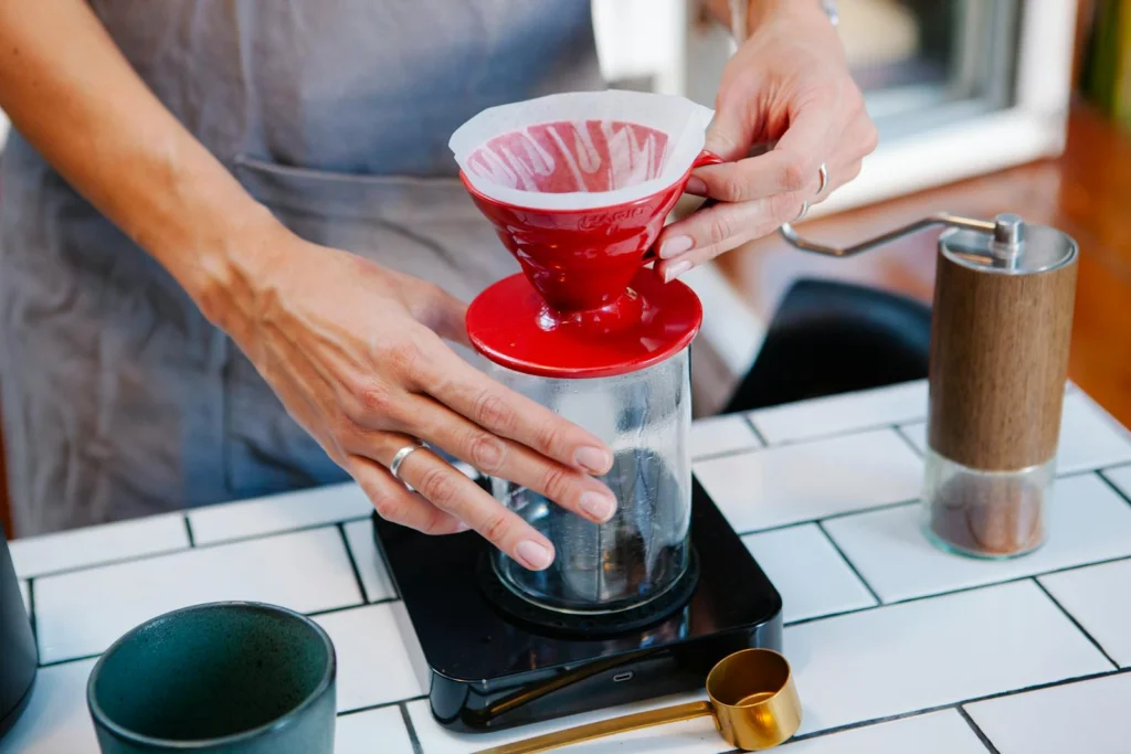 Hands-on demonstration of pour over coffee making in a cozy kitchen setting.