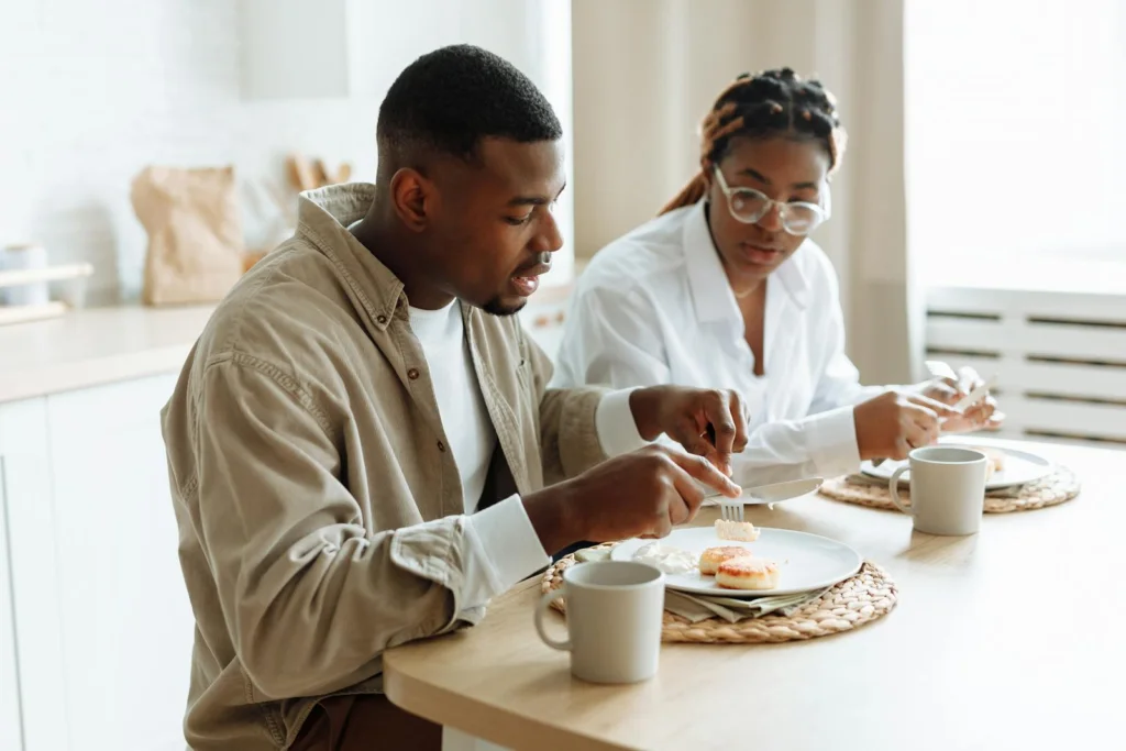 A loving couple enjoying a breakfast meal together at a cozy indoor setting.
