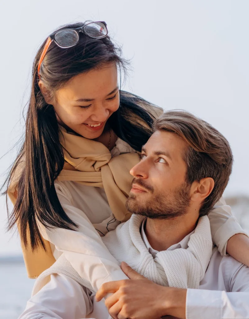 A romantic couple embracing outdoors on a cool autumn day, sharing a loving moment.