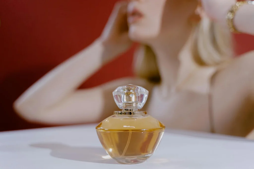 Stylish perfume bottle with a blurred woman in the background, capturing elegance and aroma.