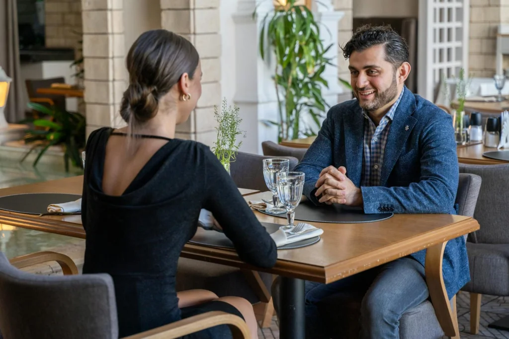 A couple having an intimate dinner at a stylish indoor café, smiling and enjoying their time together.