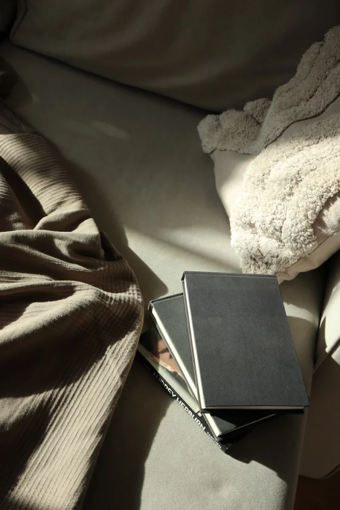 A stack of books sitting on top of a couch
