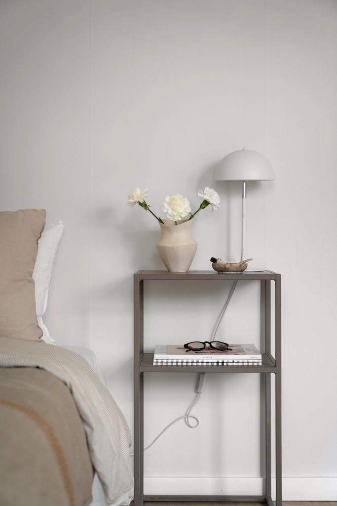A serene minimalist bedroom showcasing beige and white tones with modern furniture.