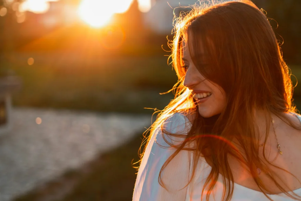 a woman with red hair is smiling at the camera