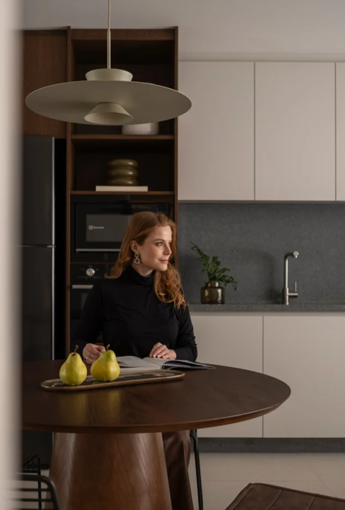 Woman in a modern kitchen with pears on table.