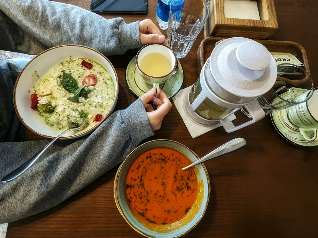 a person sitting at a table with a bowl of soup and a bowl of soup