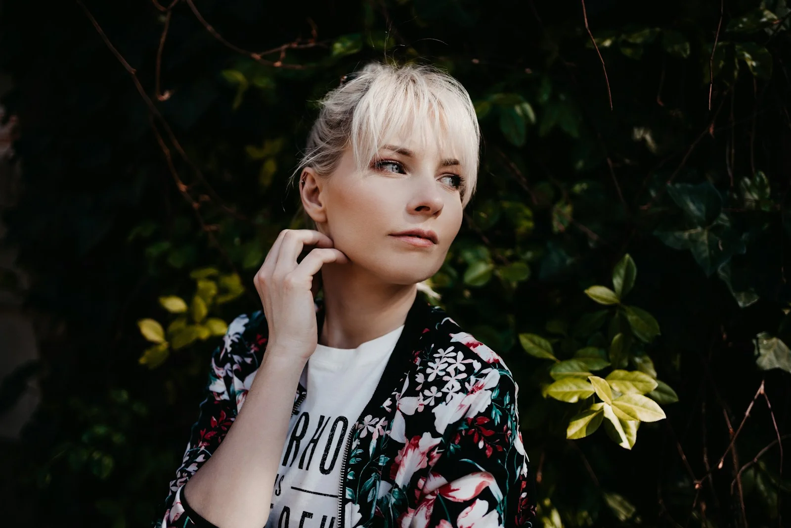 girl in black and white floral shirt standing near green plant during daytime