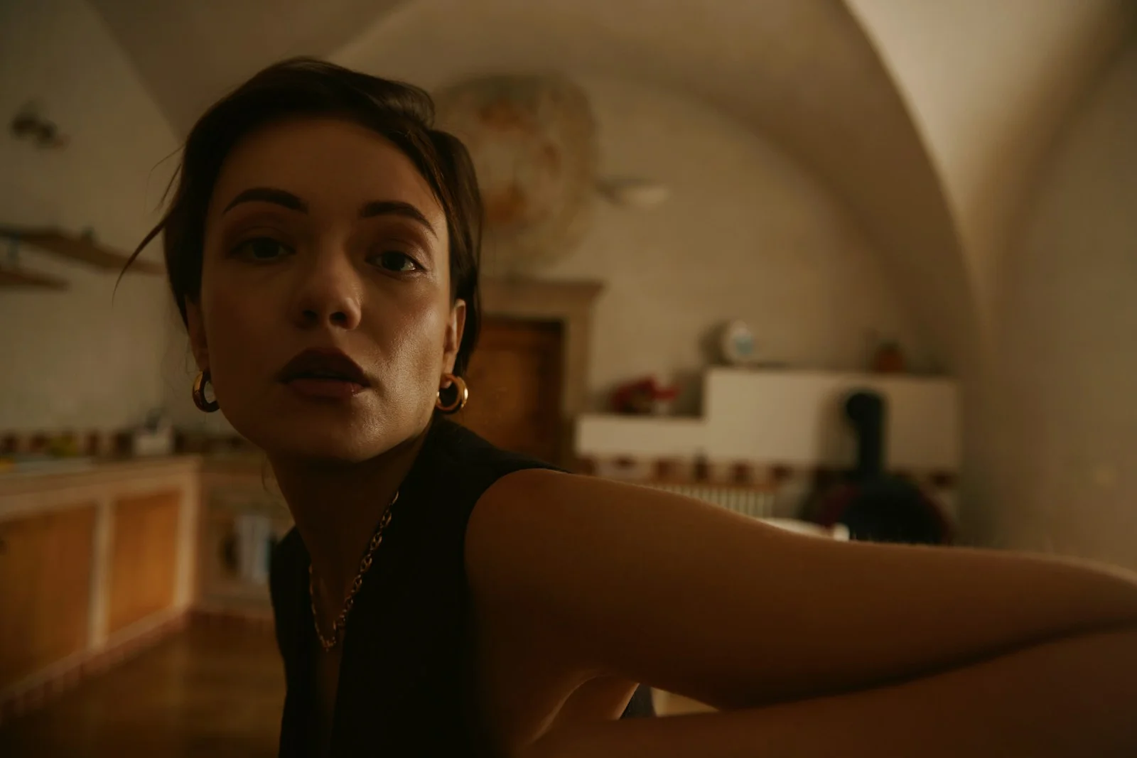 A woman sitting on the floor in a kitchen