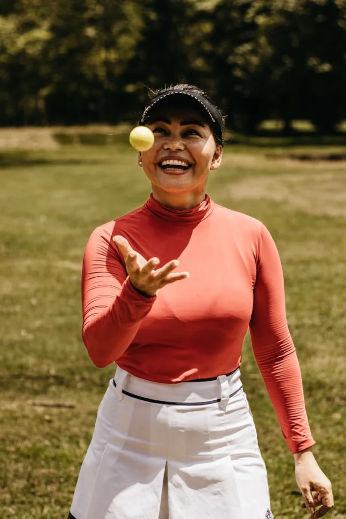 a woman holding a tennis racket and a tennis ball