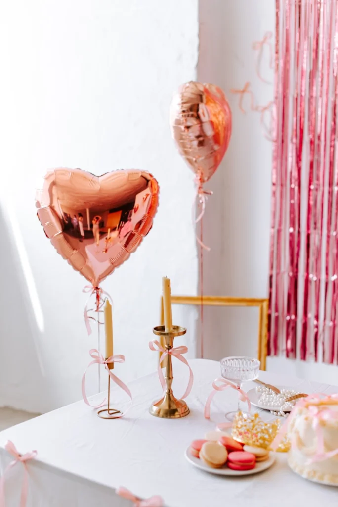 A table topped with a cake and balloons