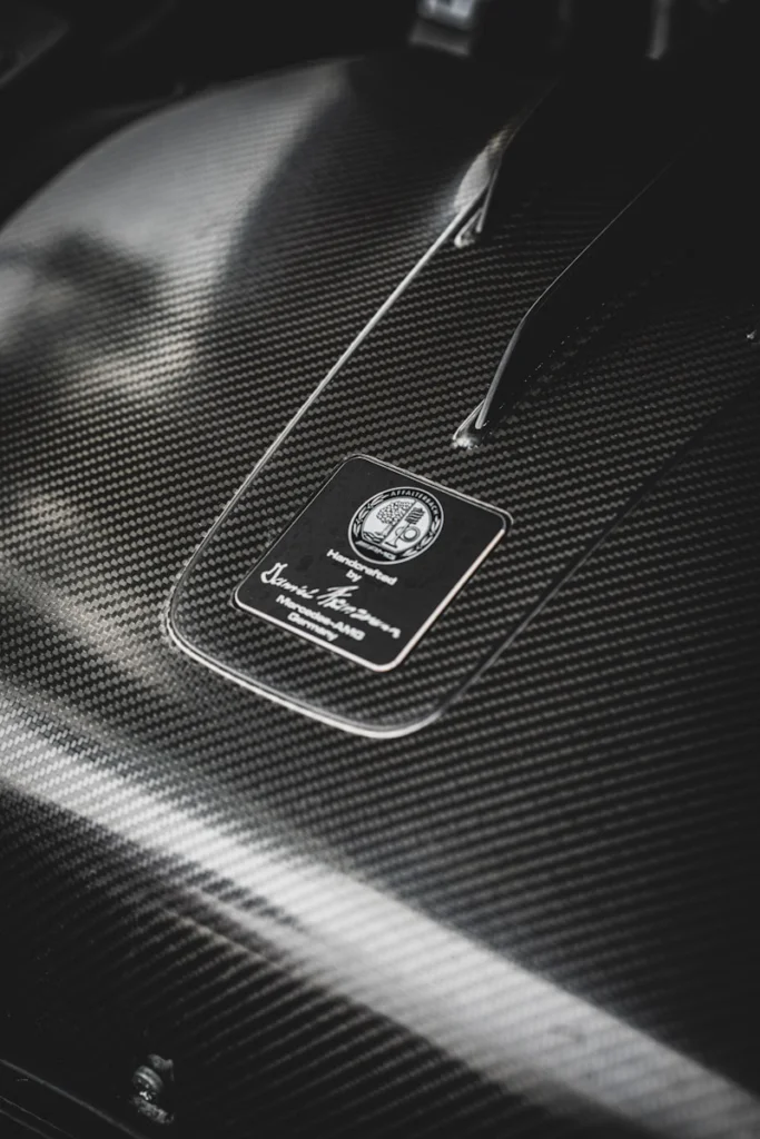 Close-up of carbon fiber engine cover with mercedes-amg badge.