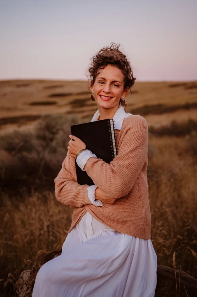 A woman sitting on a rock in a field