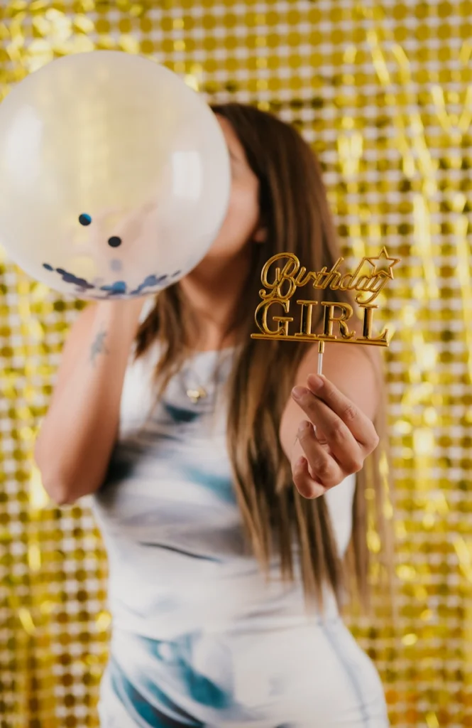 A woman holding a white balloon in front of her face