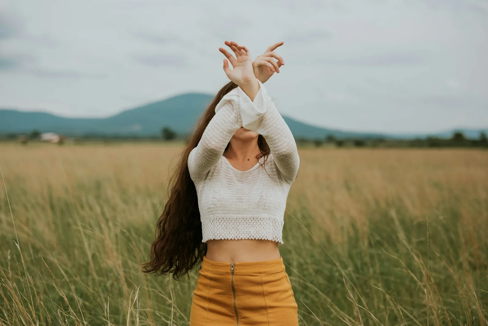 woman wearing gray crop top sweater on grass field