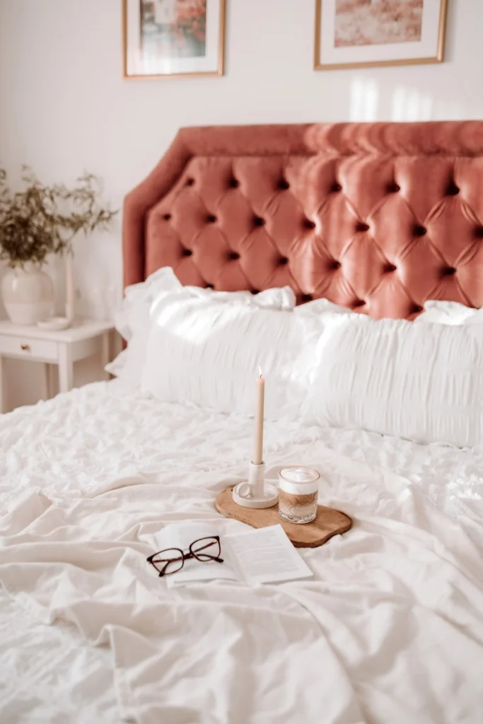 a candle on a tray on a bed