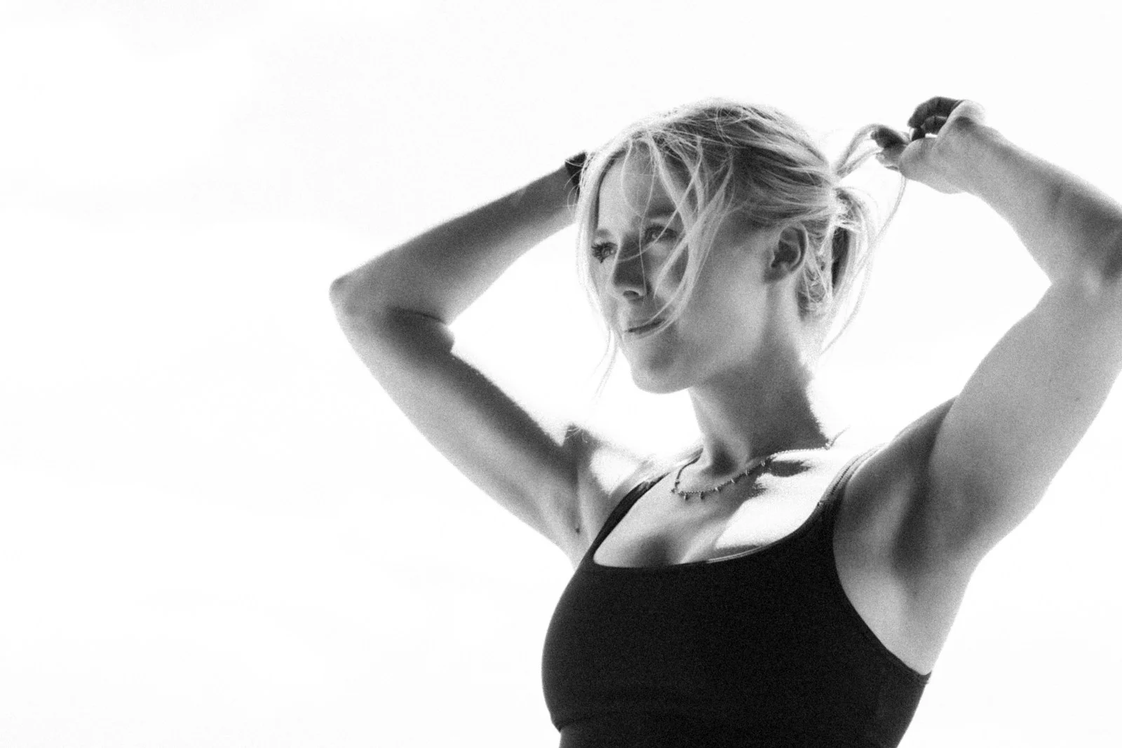 A woman in a bathing suit holding her hair