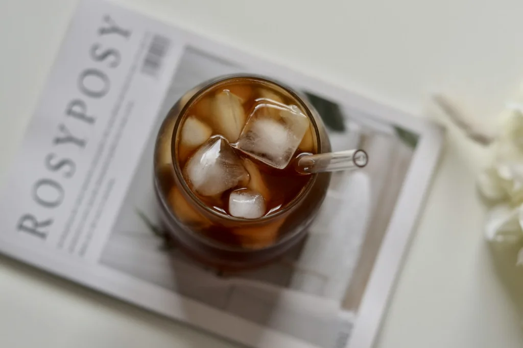 Iced coffee sits on a magazine.