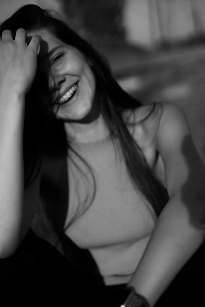 Happy woman smiles, playing with her hair.