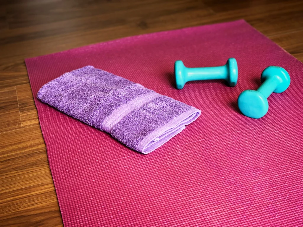 Yoga mat, weights, and a towel ready for a workout.
