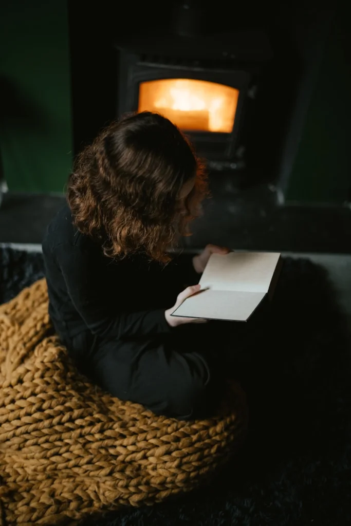 a woman sitting on the floor reading a book