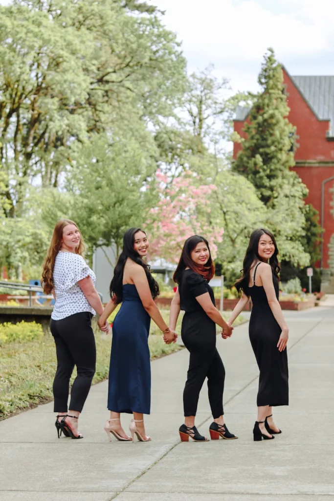 a group of women standing next to each other holding hands
