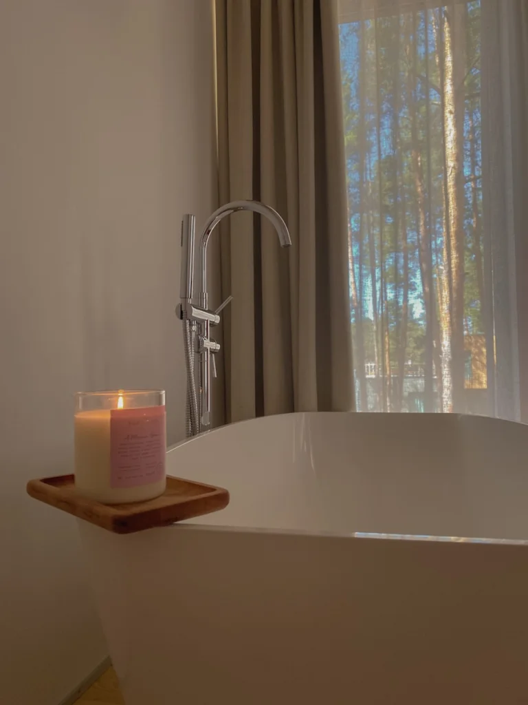 a candle sitting on top of a bathtub next to a window