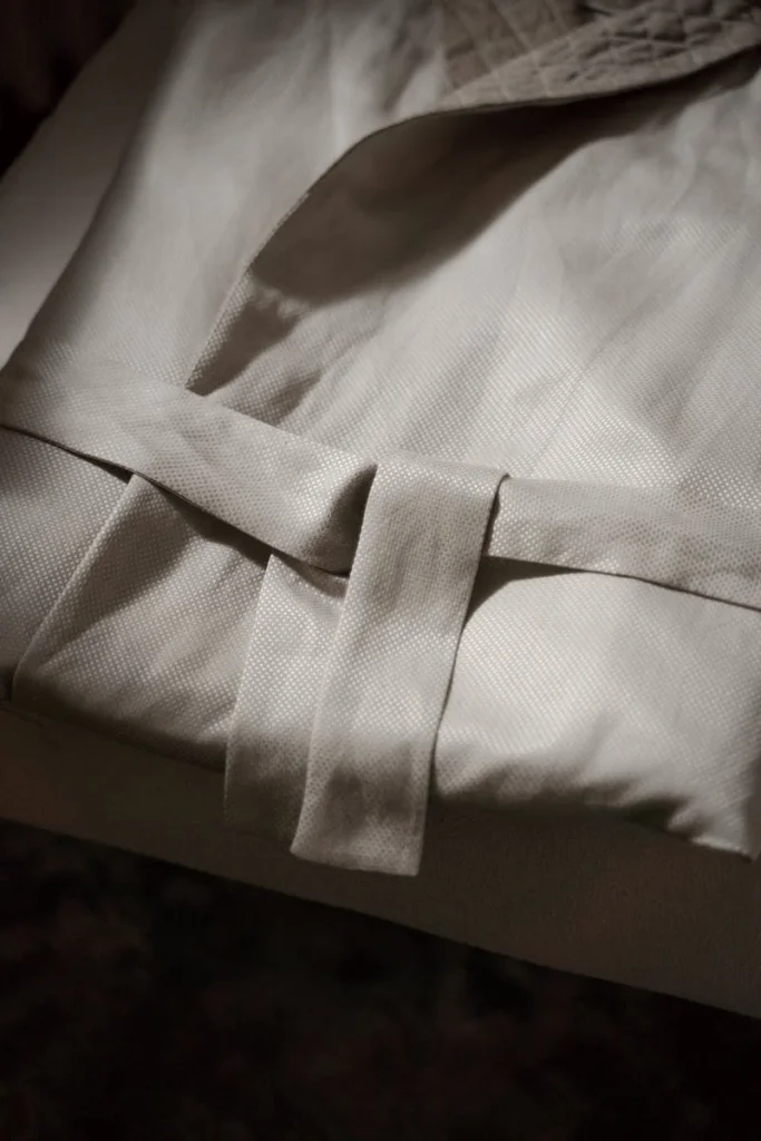 A neatly folded bathrobe with a belt, perfect for home relaxation and sleepwear.