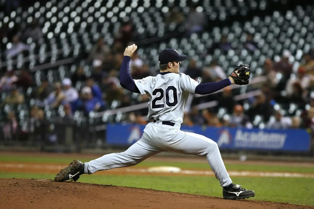 Baseball player pitching on field during a game, showcasing athletic action and focus.