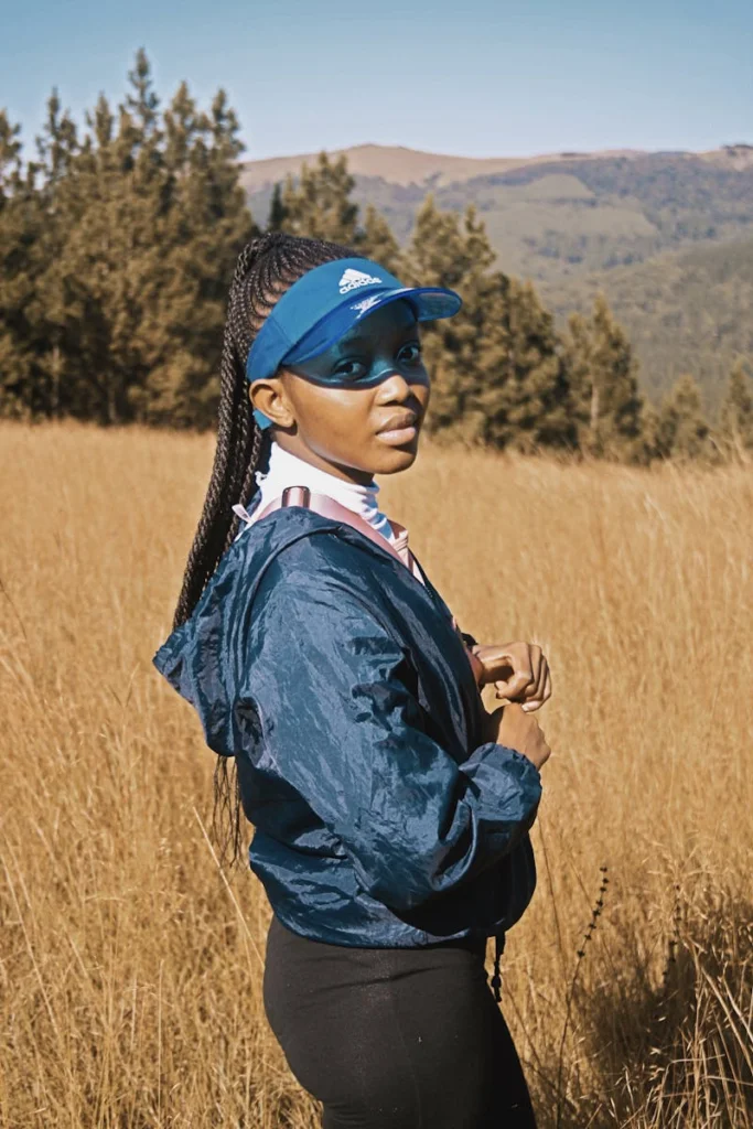 Woman in athletic wear enjoys a sunny day in the mountains.