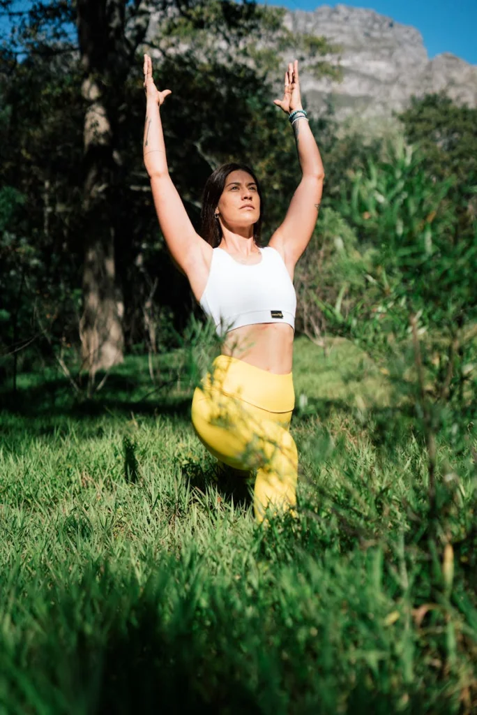A woman in a yoga pose outdoors, amidst lush greenery, promoting wellness and tranquility.