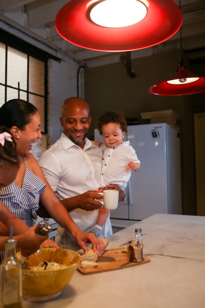 A happy family enjoys cooking together in a warmly lit kitchen, emphasizing togetherness and healthy eating.