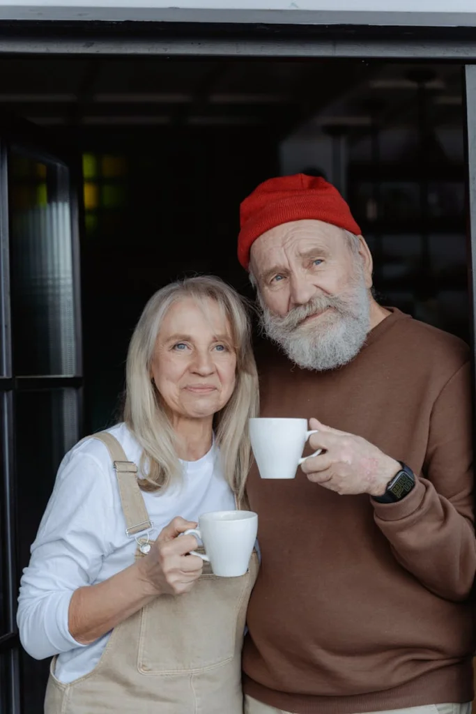 Happy elderly couple enjoying coffee together indoors, embracing love and companionship.